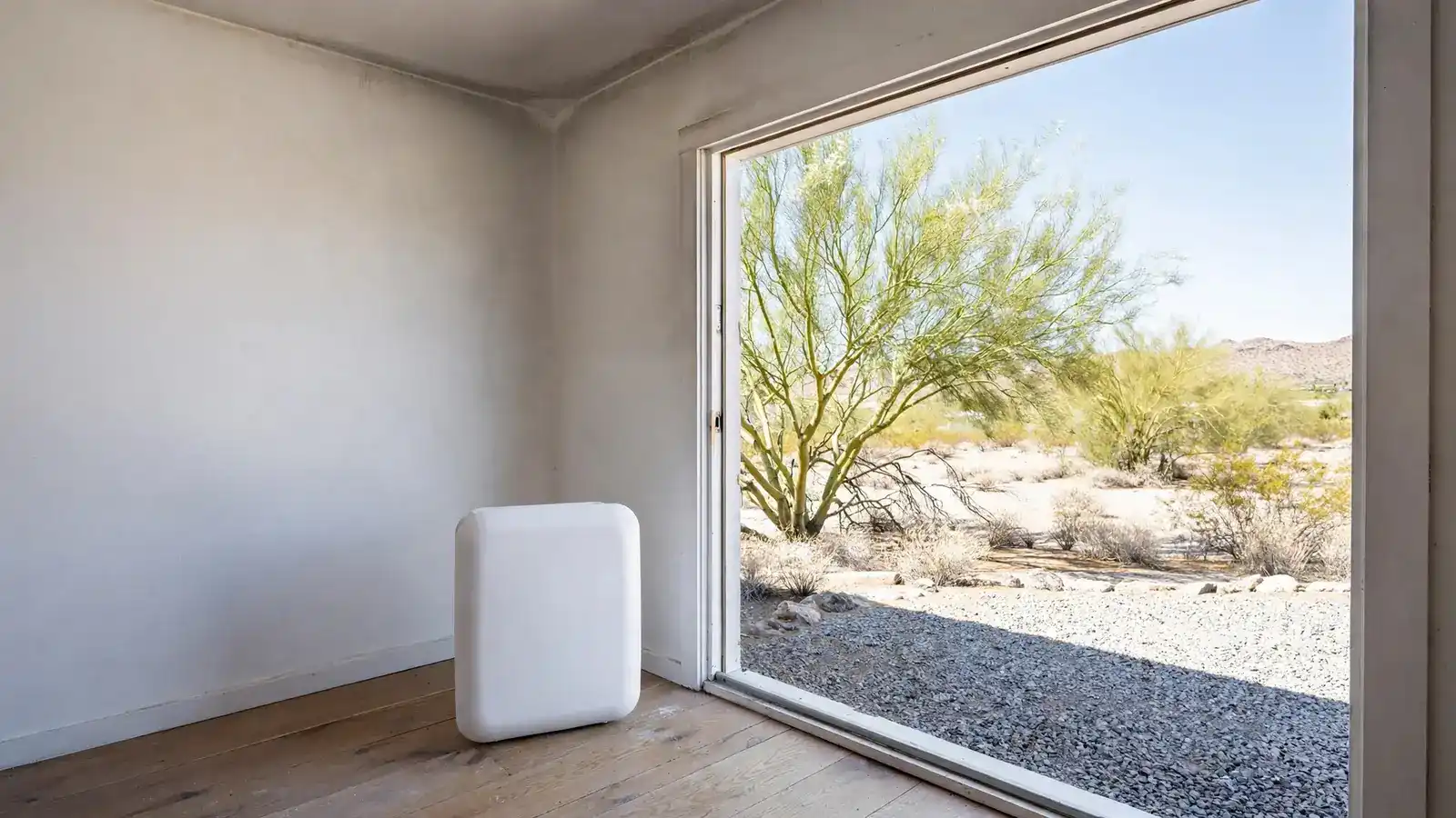 Air purifier on a wood floor beside an open window